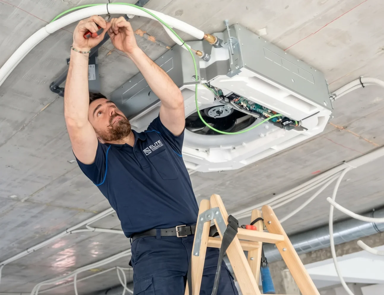 Elite Mechanical Systems technician installing a ceiling cassette mini split